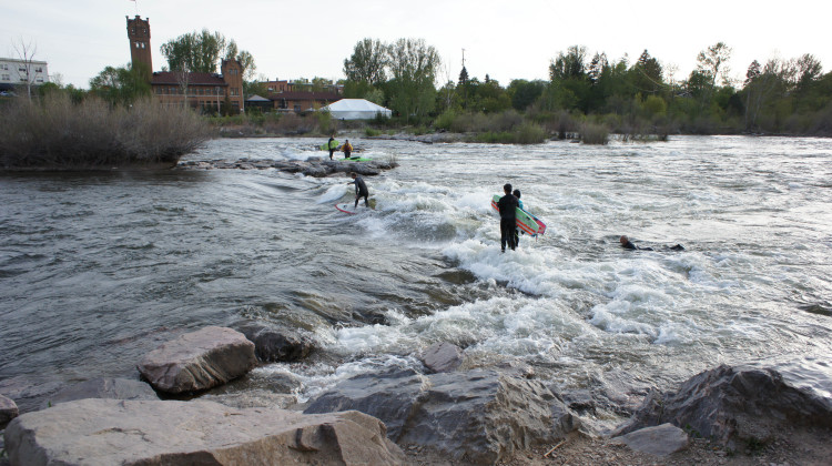 Surfers riding river waves downtown Missoula, Montana